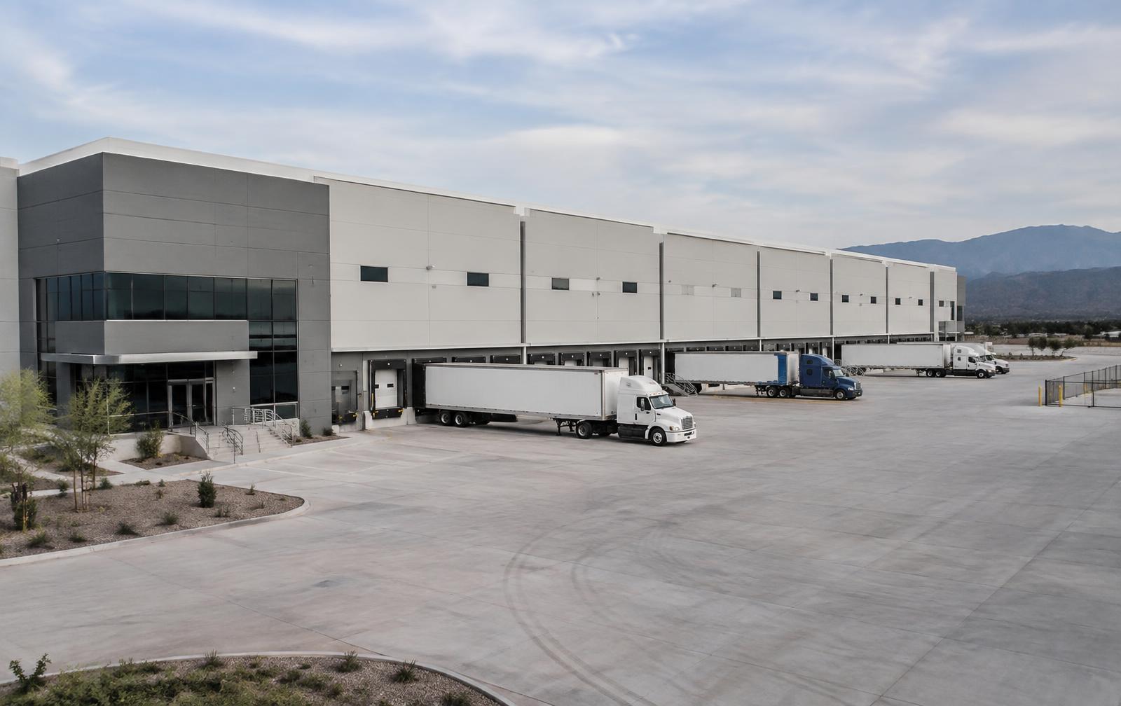 Modern industrial facility with loading docks and freight trucks