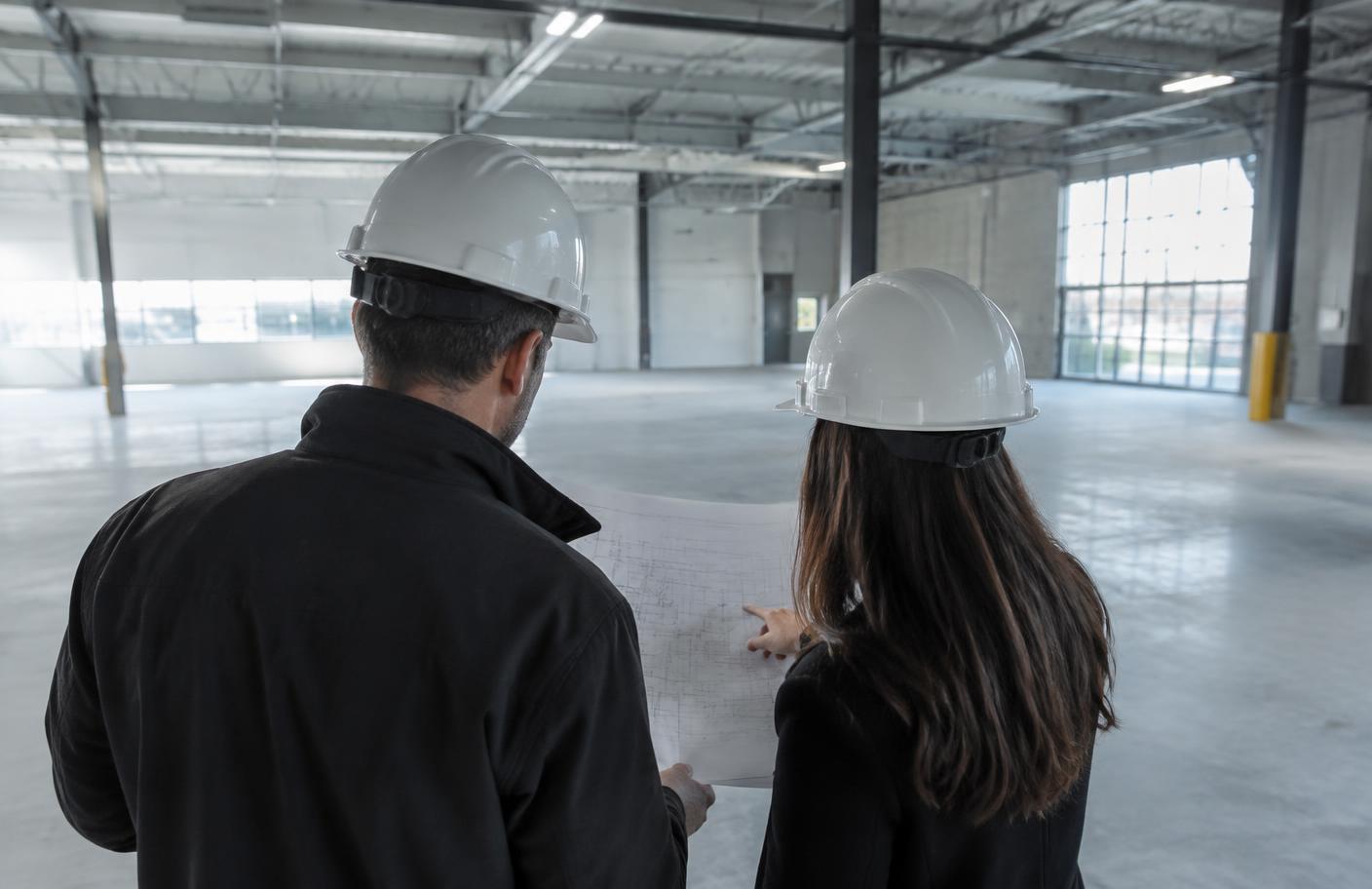 Professionals reviewing plans during an industrial site walk
